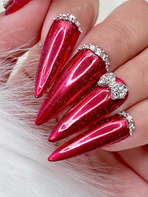 Long stiletto gel red New Years nails with a touch of silver shimmer and rhinestones above each nail cuticle