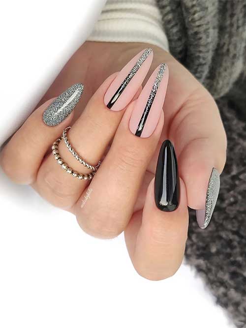 Nude and black New Year nail design features two sparkling black nails with silver glitter, and two nude pink nail design