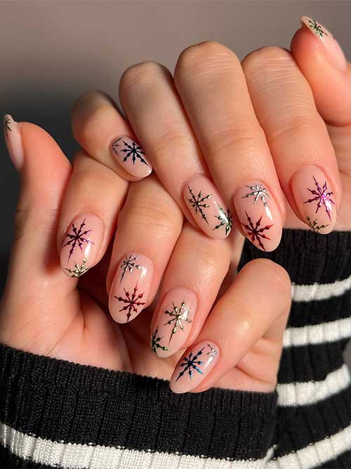 Short nude almond Christmas nails with different colored chrome snowflakes.