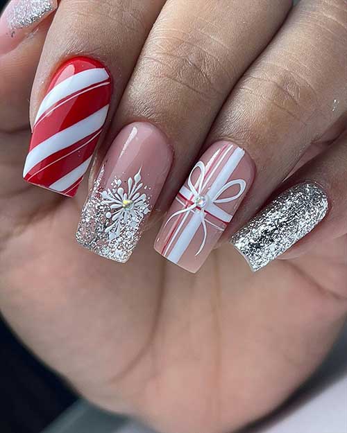 Silver glitter sparkling Christmas nails with an accent nail adorned with candy cane nail art, plaid, and gift tie nail art
