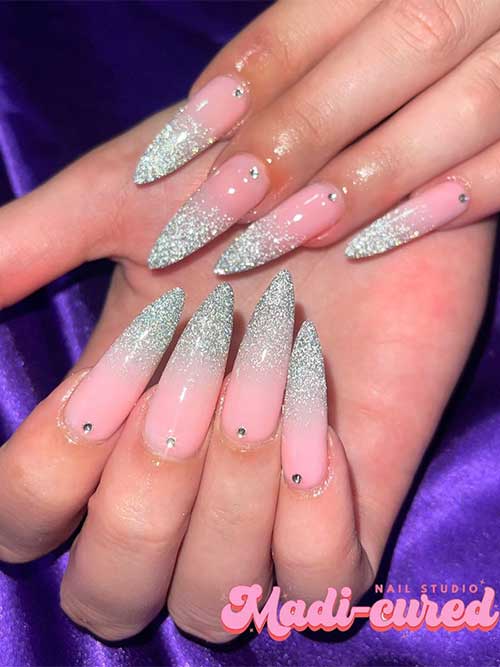 Sparkling long silver glitter French tip New Year’s nails with a crystal above the cuticle on each nail