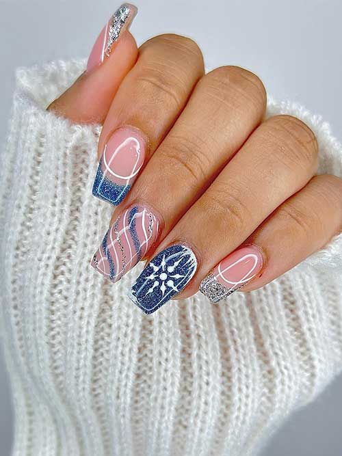 Sparkling navy blue winter nails with two silver glitter French tip nails and another glitter candy cane accent nail