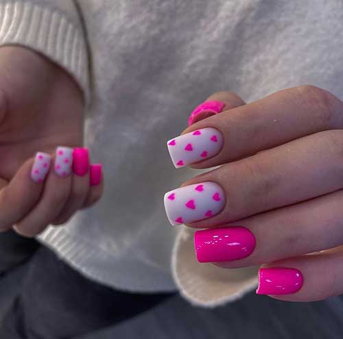 Glossy hot pink Valentine’s nails with two accent matte white nails adorned with hot pin tiny hearts