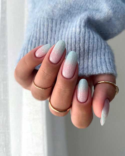 Gorgeous pink to pastel blue turquoise ombre nails adorned with silver glitter are the best of the winter nail art designs