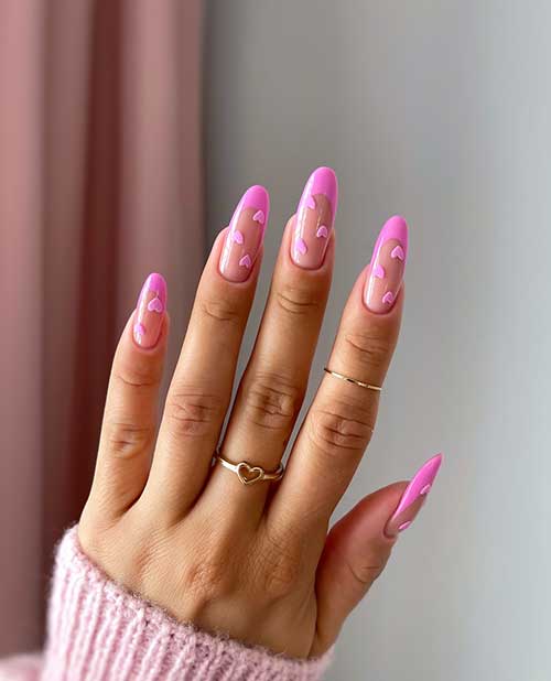 Long almond-shaped candy pink Valentine’s Day nails with glued tiny candy pink heart shapes