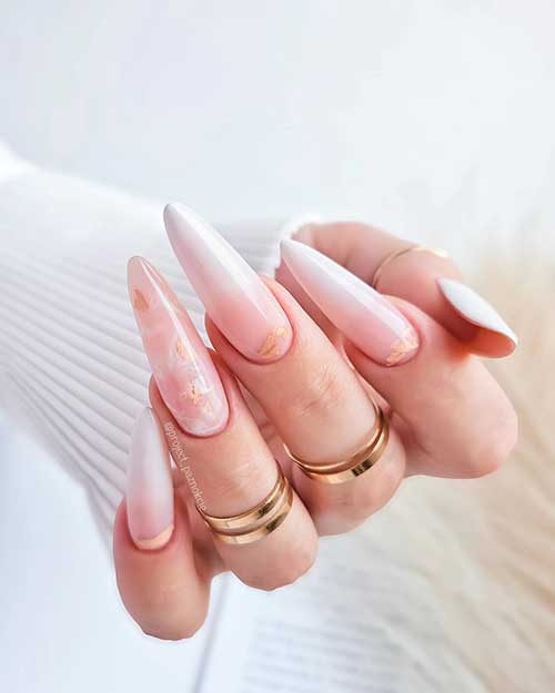Long almond-shaped gel baby boomer nails with milky white tips, a marble effect, and, some beige patch decorations