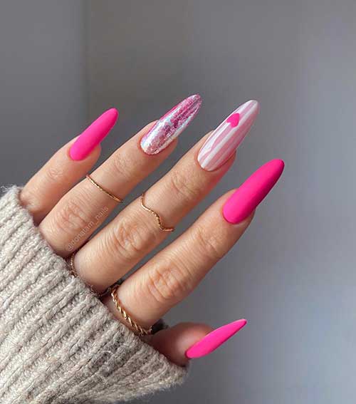 Long almond-shaped neon pink Valentine’s nails with a nude pink accent nail adorned with white stripes and a red heart