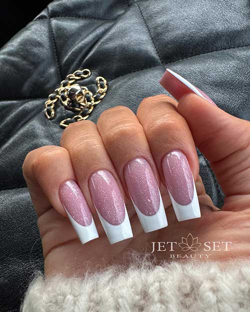 Long square-shaped White French nails over shimmering base color featuring sparkling gold glitter