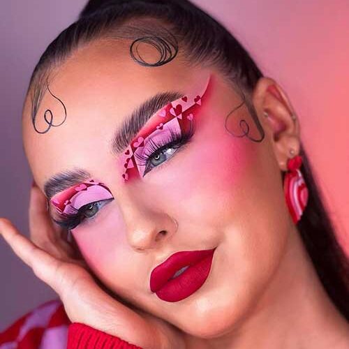 Matte Valentine's Day makeup look features red and pink eyeshadow with heart shapes and velvet red lips