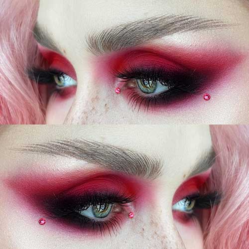 Red Valentine's Day eye makeup with black smokey eyes with a red rhinestone on each of the inner and outer eye corners