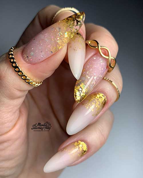 Stunning long almond-shaped French ombre nails with glitter and gold foil decorations