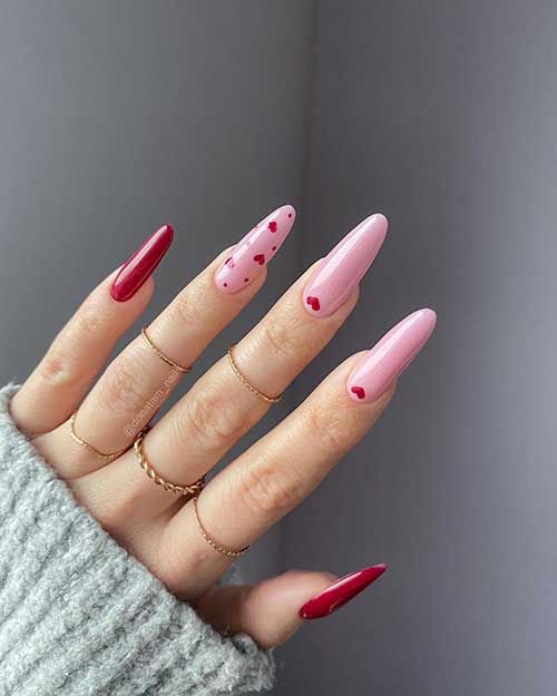 Stunning pink and red Valentine’s nails with red hearts on the pink nails. and two accent solid red nails