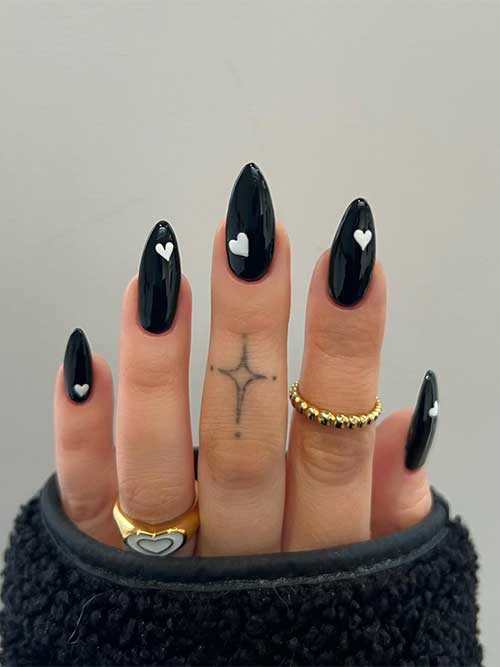 Almond-shaped simple black Valentine’s Day nails with a white heart shape on each nail