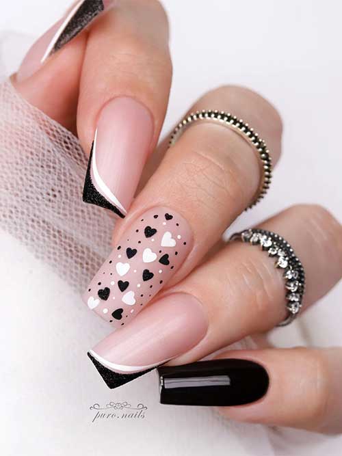 Double white and black diagonal French nails with an accent black nail, and a nude nail adorned with black and white hearts Double white and black diagonal French nails with an accent black nail, and a nude nail adorned with black and white hearts