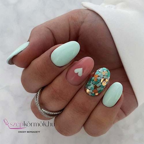 Glossy short mint green pastel Valentine’s Day nails with a nude accent nail adorned with a mint green heart shape
