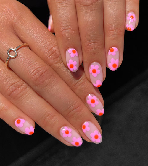 Gorgeous short nude nails adorned with pink flowers with a red circle on each flower center