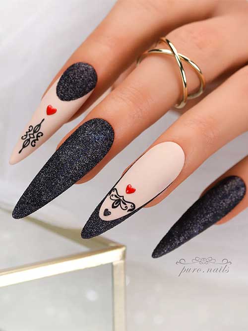 Long almond-shaped sparkling glitter black nails with accent French tip nails adorned with black and red hearts