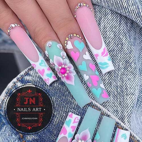 Long coffin mint green and white pastel Valentine’s Day nails adorned with rhinestones, floral nail art, and heart shapes