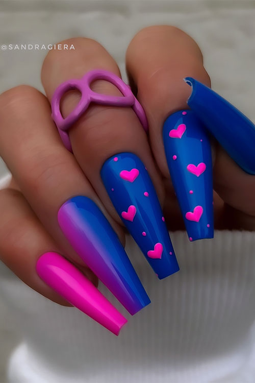 Long coffin-shaped royal blue Valentine's Day nails adorned with hot pink heart shapes on two accent royal blue nails