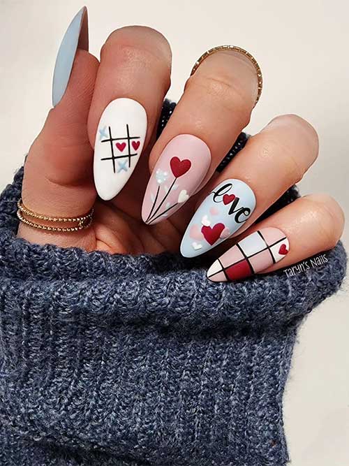 Matte light blue, light pink, and white pastel Valentine’s Day nails with red hearts and different romantic nail art design