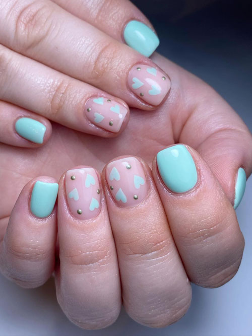 Short mint green nails with two accent nude nails adorned with mint green hearts and gold dots