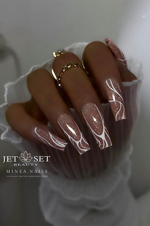 Stunning coffin glossy nude nails with a touch of gold glitter and white swirls Stunning coffin glossy nude nails with a touch of gold glitter and white swirls