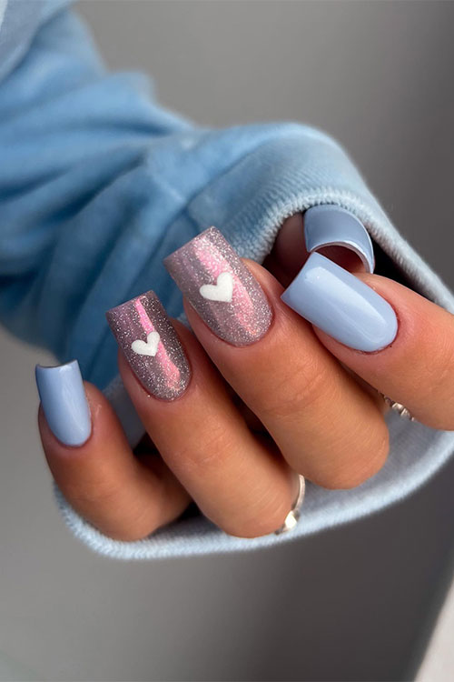 Stunning sky blue Valentine's Day nails with two accent shimmer pink nails adorned with a white heart shape on each nail