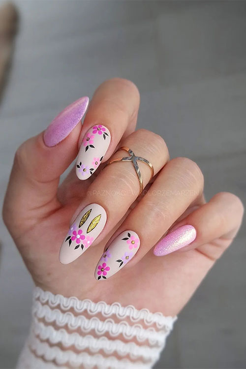 Pink Easter nails that feature light pink and purple, gold bunny, and two shimmer light pink gel nails