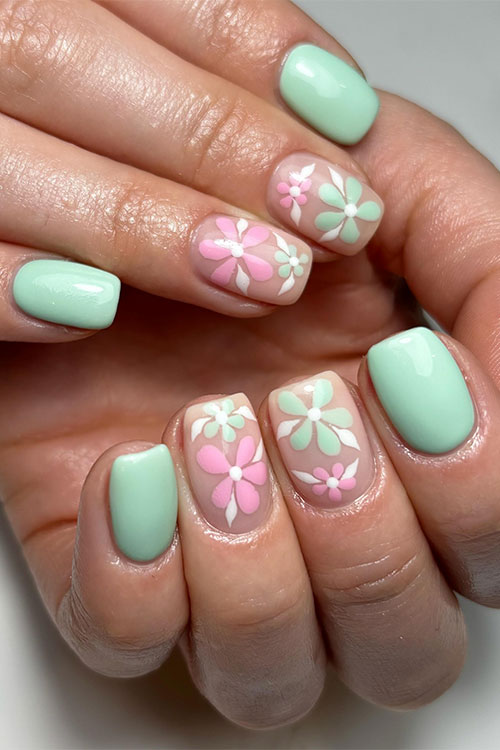 Short mint green nails with two accent nude nails adorned with pink and mint green flowers with white leaves Short mint green nails with two accent nude nails adorned with pink and mint green flowers with white leaves