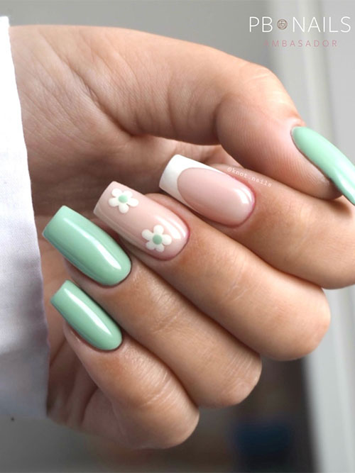 Simple mint green nails squared shaped adorned with a classic white French tip and a nude nail adorned with white flowers