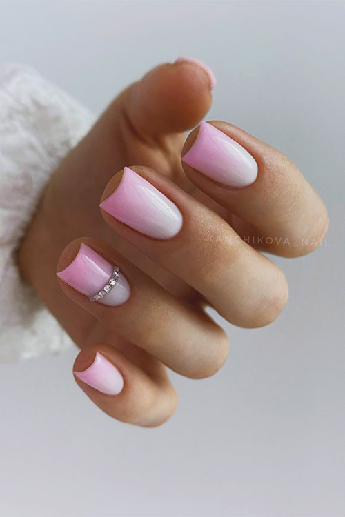 Short pastel pink ombre nails with some crystals on an accent nail