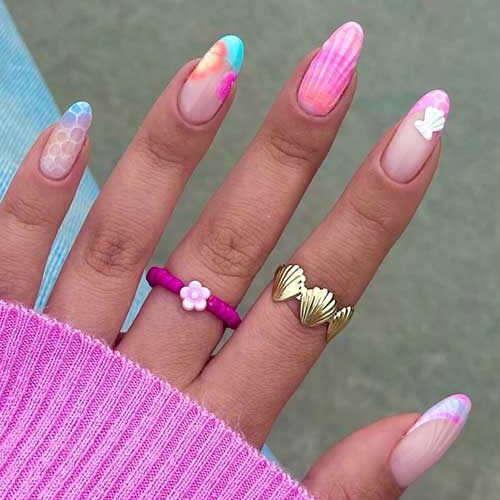 Colorful seashell-inspired nails with honeycomb patterns, pastel French tips, and 3D seashell accents for a summer vibe.