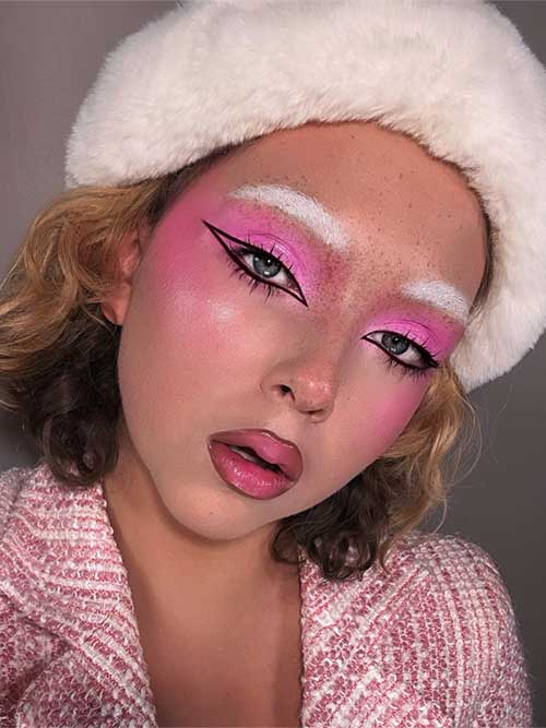 Daring pink makeup with vibrant eyeshadow, sleek winged eyeliner, bleached brows, and glossy lips for a fun, high-fashion look. Daring pink makeup with vibrant eyeshadow, sleek winged eyeliner, bleached brows, and glossy lips for a fun, high-fashion look.