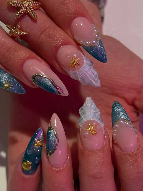 Ocean-inspired stiletto nails featuring 3D seashells, glittery blues, pearls, and gold starfish for a glamorous summer style. Ocean-inspired stiletto nails featuring 3D seashells, glittery blues, pearls, and gold starfish for a glamorous summer style.