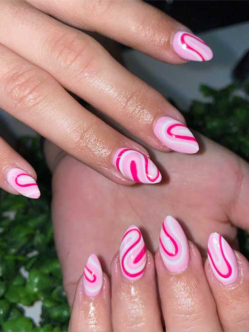 Pink and white swirl nails with a soft pink base and vibrant patterns, resembling a whimsical candy shop treat. Pink and white swirl nails with a soft pink base and vibrant patterns, resembling a whimsical candy shop treat.