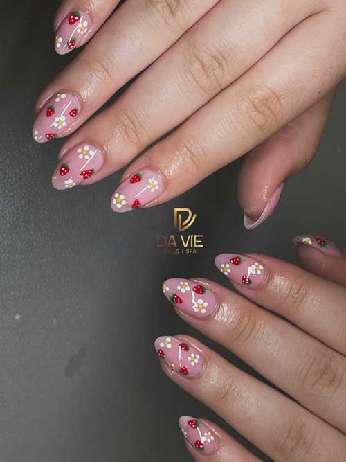 Playful strawberry-themed nails on a soft nude pink base, showcasing red berries, green leaves, and delicate white floral accents. Playful strawberry-themed nails on a soft nude pink base, showcasing red berries, green leaves, and delicate white floral accents.