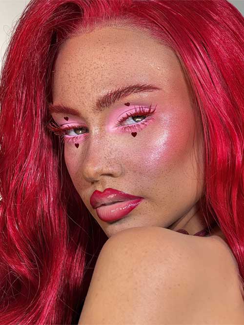 Romantic makeup featuring pink eyeshadow, heart accents, blushed cheeks, glossy red lips, and vibrant red hair and outfit. Romantic makeup featuring pink eyeshadow, heart accents, blushed cheeks, glossy red lips, and vibrant red hair and outfit.