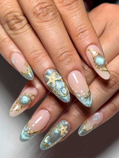 Shimmering blue glitter seashell nails with gold accents and starfish details, evoking an enchanting underwater paradise. Shimmering blue glitter seashell nails with gold accents and starfish details, evoking an enchanting underwater paradise.
