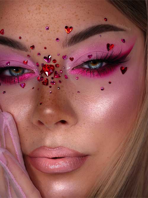 Soft pink eyeshadow look with vibrant glitter, adorned with heart-shaped embellishments and rhinestones for a romantic style. Soft pink eyeshadow look with vibrant glitter, adorned with heart-shaped embellishments and rhinestones for a romantic style.
