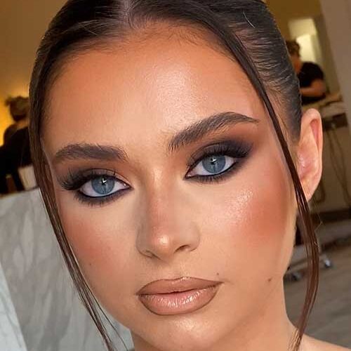 Bold smokey eyeshadow for blue eyes, featuring matte black and brown tones, highlighted inner corners, and neutral lips.