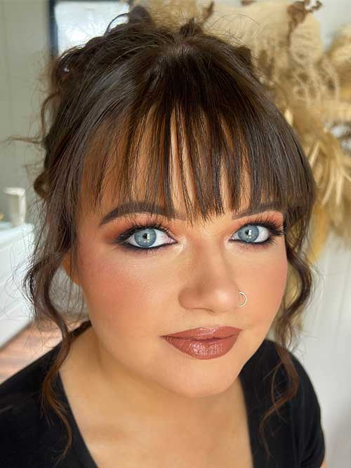 Elegant makeup look for blue eyes featuring warm-toned eyeshadows, defined eyeliner, lush lashes, rosy blush, and nude lip. Elegant makeup look for blue eyes featuring warm-toned eyeshadows, defined eyeliner, lush lashes, rosy blush, and nude lip.