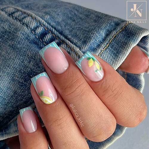 Fruit nails French tip with milky pink base, light blue tips, white stripes, and hand-painted lemons on ring and index fingers.