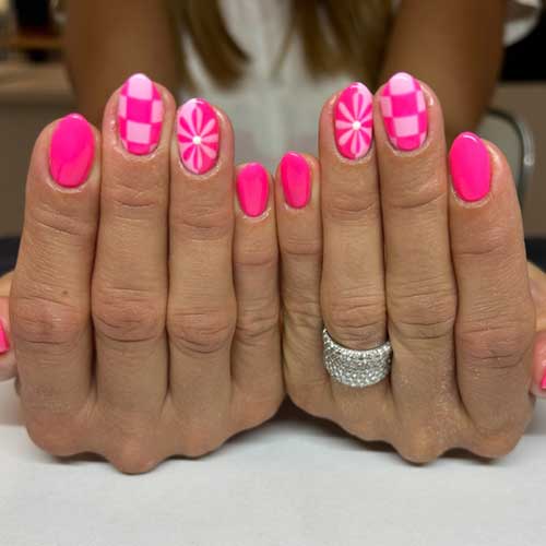 Hot pink short nails with a checkerboard design and floral accents, showcasing a fun retro style and vibrant flair. Hot pink short nails with a checkerboard design and floral accents, showcasing a fun retro style and vibrant flair.