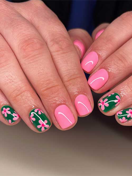 Short nail design featuring solid pink nails and green nails with delicate pink flowers, evoking a vibrant garden look. Short nail design featuring solid pink nails and green nails with delicate pink flowers, evoking a vibrant garden look.