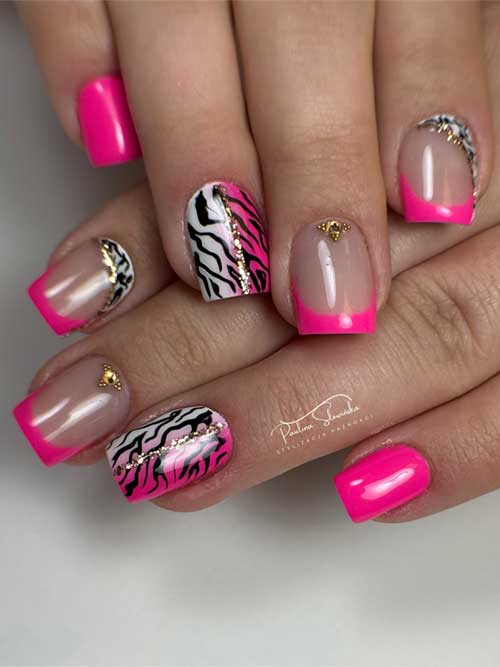 Short nails with vibrant pink French tips, zebra print, gold glitter stripes, and studs for a bold, chic look. Short nails with vibrant pink French tips, zebra print, gold glitter stripes, and studs for a bold, chic look.