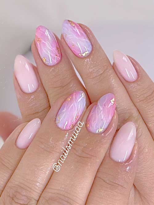 Short pink nails with marble effects in white and lavender, accented with gold foil for a luxurious and elegant look. Short pink nails with marble effects in white and lavender, accented with gold foil for a luxurious and elegant look.