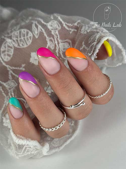 Vibrant matte multicolor nails with bold tips, chic nude base, and elegant gold stripes for a modern twist on French design. Vibrant matte multicolor nails with bold tips, chic nude base, and elegant gold stripes for a modern twist on French design.