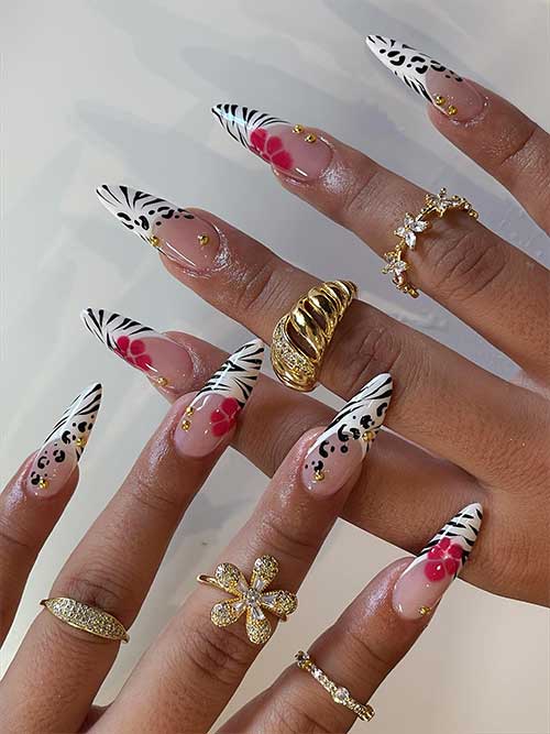 Animal print stiletto nails combine zebra and leopard designs with elegant red flowers and gold studs for a striking effect.