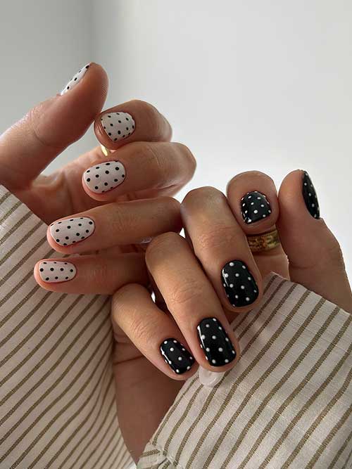 Black and white polka dot nails: one hand with white nails and black dots, the other with the reverse design, stylish and versatile. Black and white polka dot nails: one hand with white nails and black dots, the other with the reverse design, stylish and versatile.