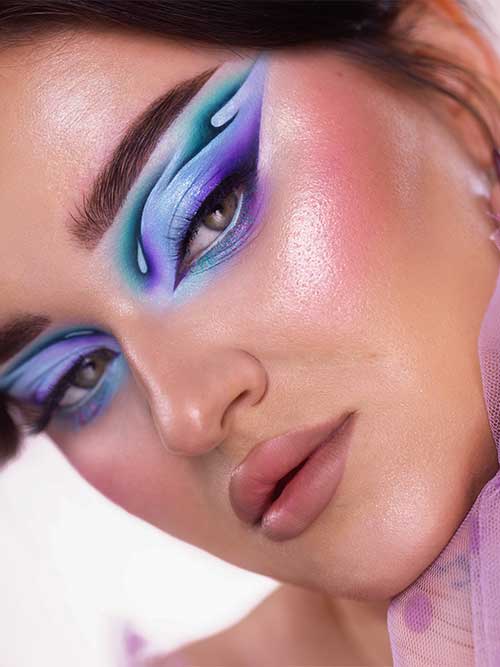 Ethereal purple eyeshadow with aqua and teal blends, paired with dewy skin and nude lips, creating a whimsical fantasy look. Ethereal purple eyeshadow with aqua and teal blends, paired with dewy skin and nude lips, creating a whimsical fantasy look.